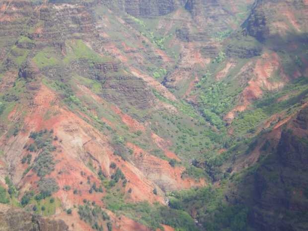 Red and grey rock, with trees and shrubs here and there like the spotty fur on a mangy dog, slope down in rough Vs to a tiny grey stream below. Red and grey rock, with trees and shrubs here and there like the spotty fur on a mangy dog, slope down in rough Vs to a tiny grey stream below.